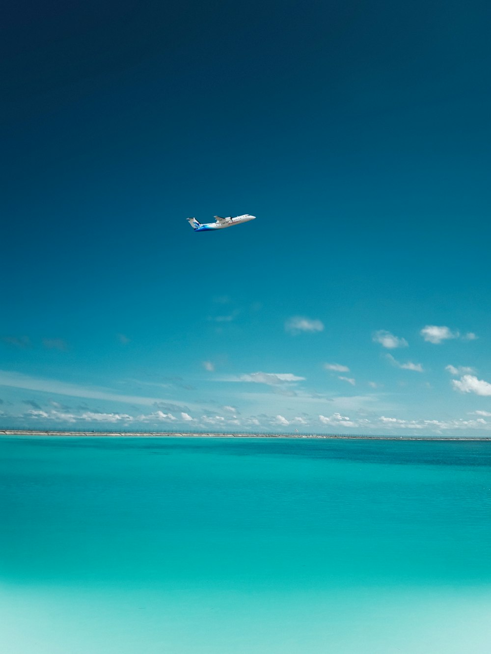 photo of airplane over body of water