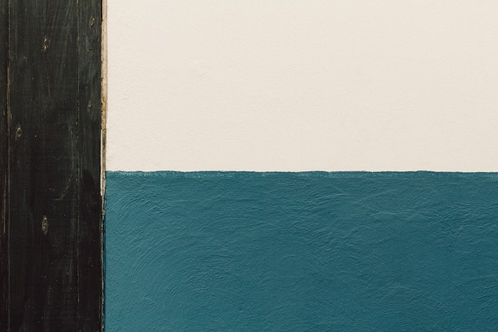 a white and blue wall next to a wooden door