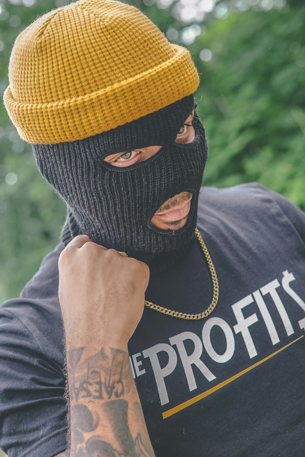 man wearing black balaclava mask and brown knit cap outdoor during daytime