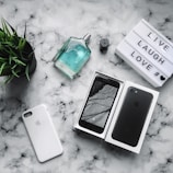 Flat lay of monay’s products on a marble countertop, surrounded by delicate petals and a gold-accented mirror.
