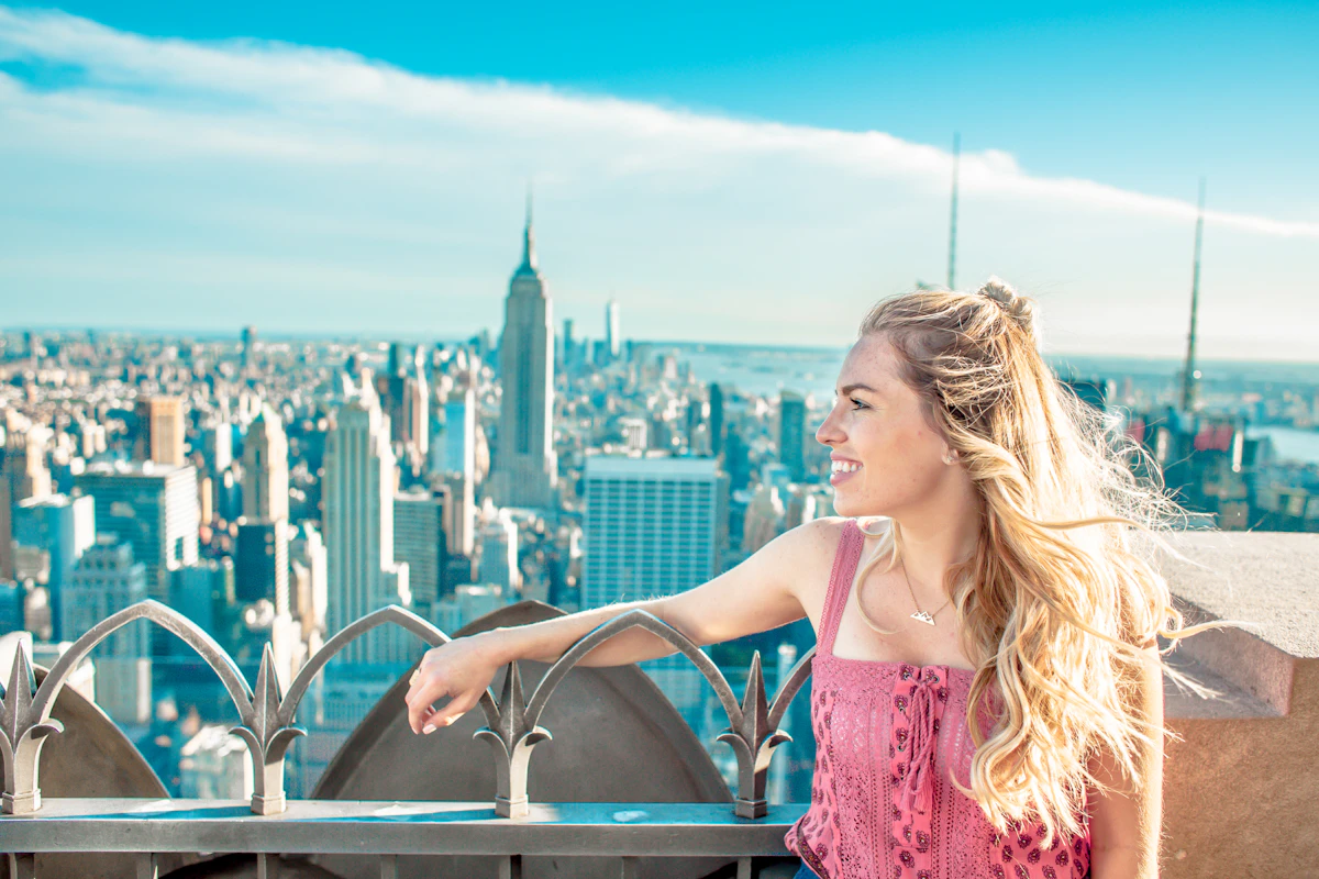 New York'ta bir gökdelenin seyir terasından Empire State Binası'na bakan genç bir kadın
