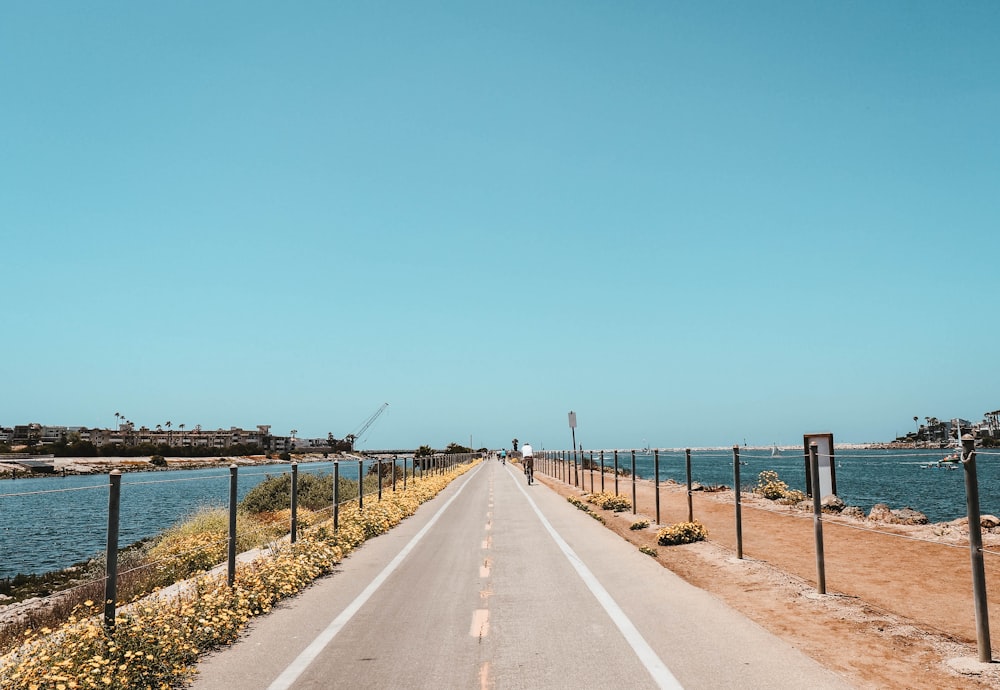 persona que pasa por la carretera bajo el cielo azul