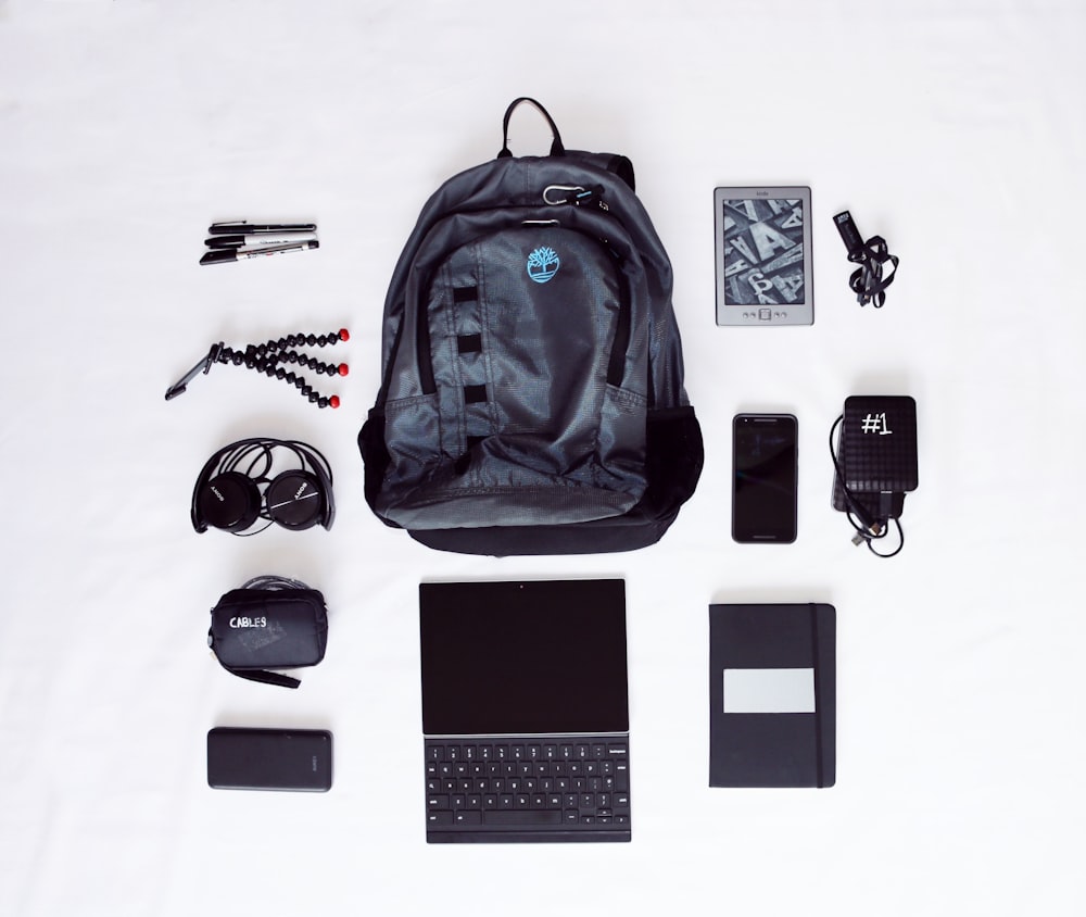 flat lay photography of backpack, laptop computer, headphones, smartphone, and octopus tripod