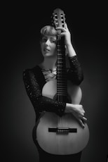 grayscale photography of woman holding guitar