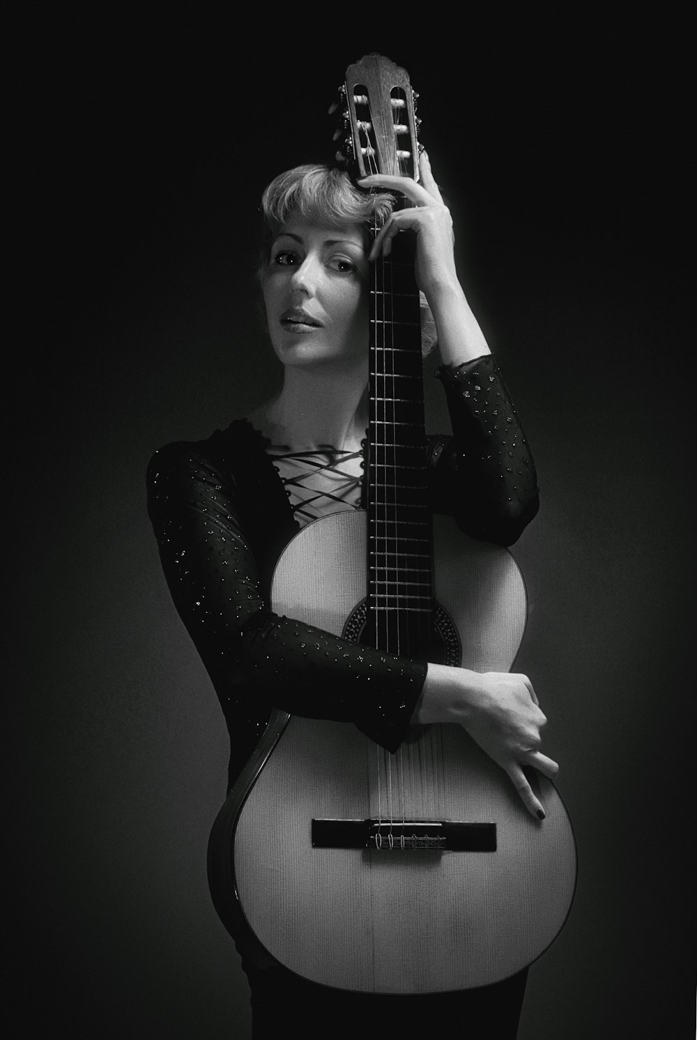 grayscale photography of woman holding guitar