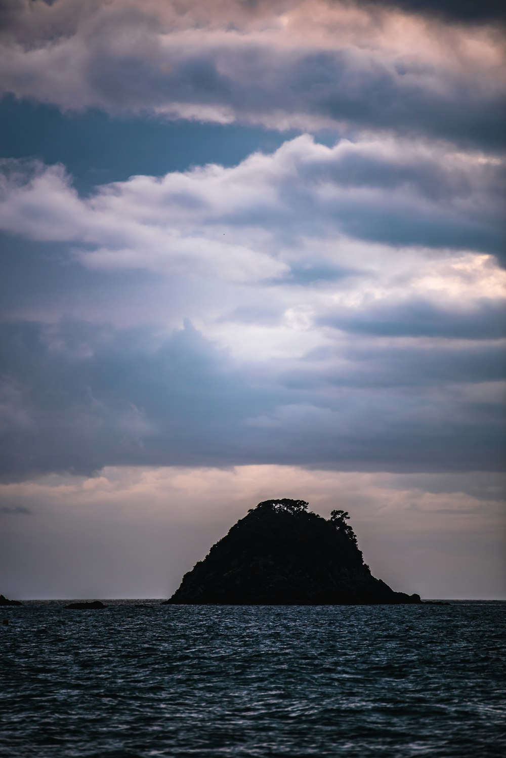 silhouette of island under cloudy sky