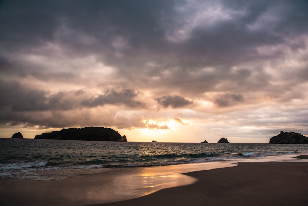 shore under cloudy sky during daytime