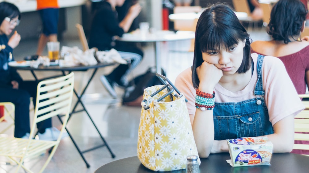 woman sitting and her right hand on her cheek