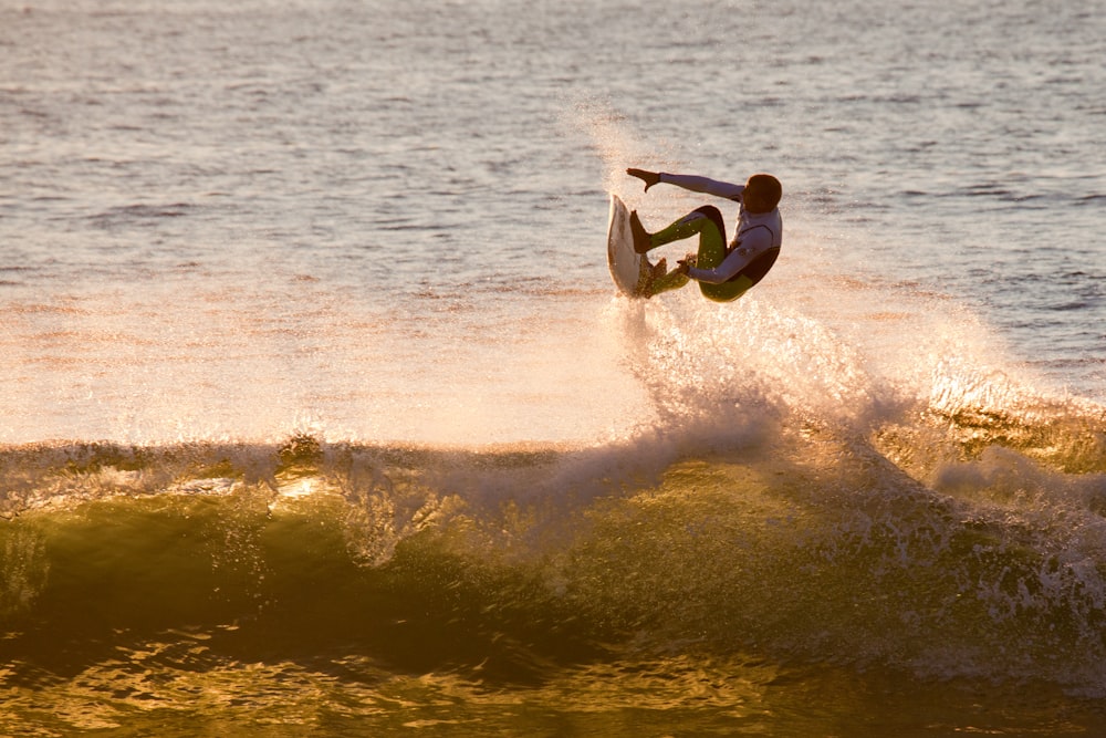 photo of man surfing during daytime