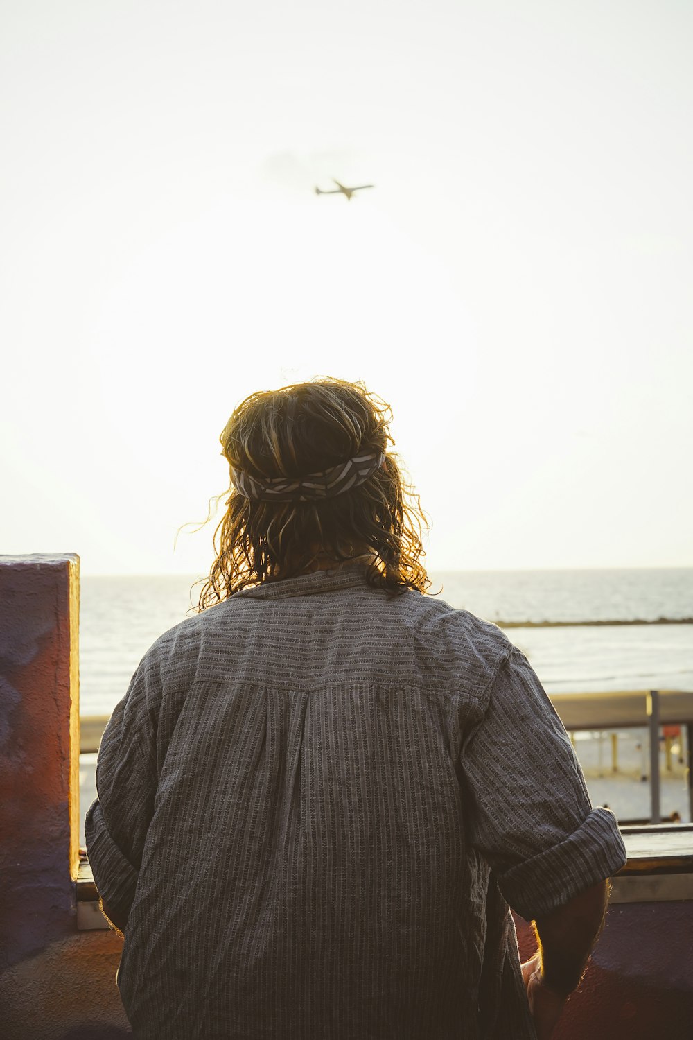 person sitting while facing to body of water