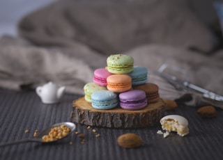 assorted-color macaroons on wood slab