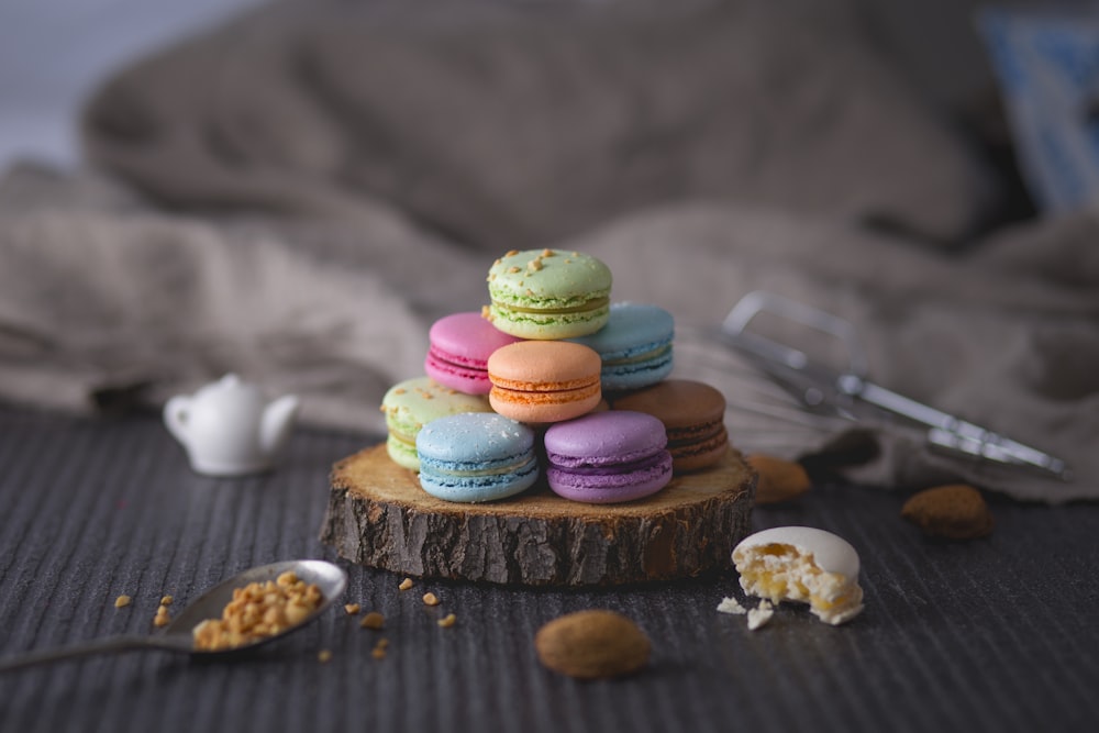 assorted-color macaroons on wood slab