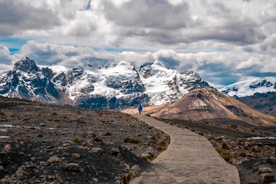 person walking toward snow-capped mountain in Nevado Pastoruri Peru