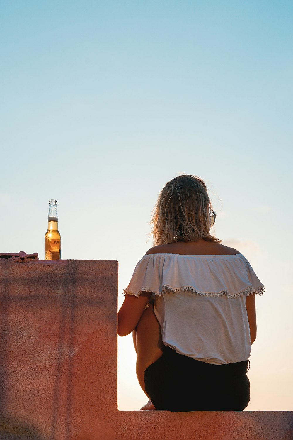 woman sitting on concrete wall