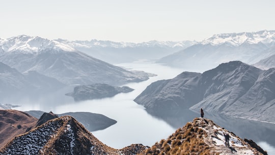 landscape photography of river between hills in Roys Peak New Zealand