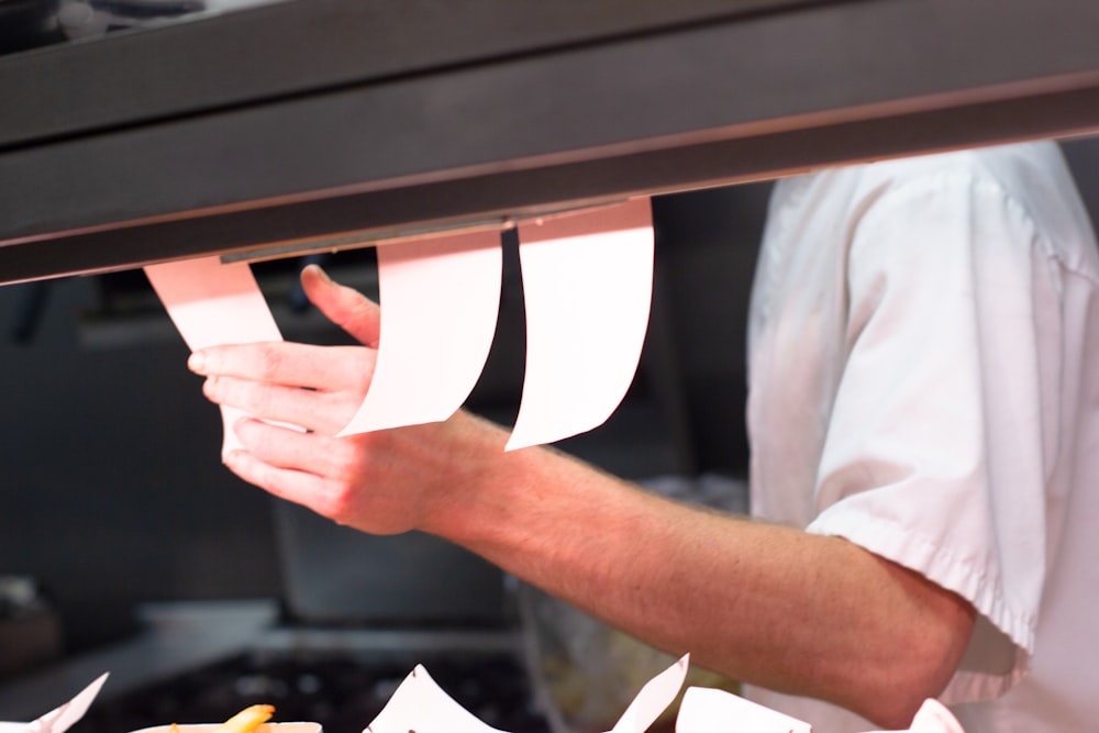 man holding white menu