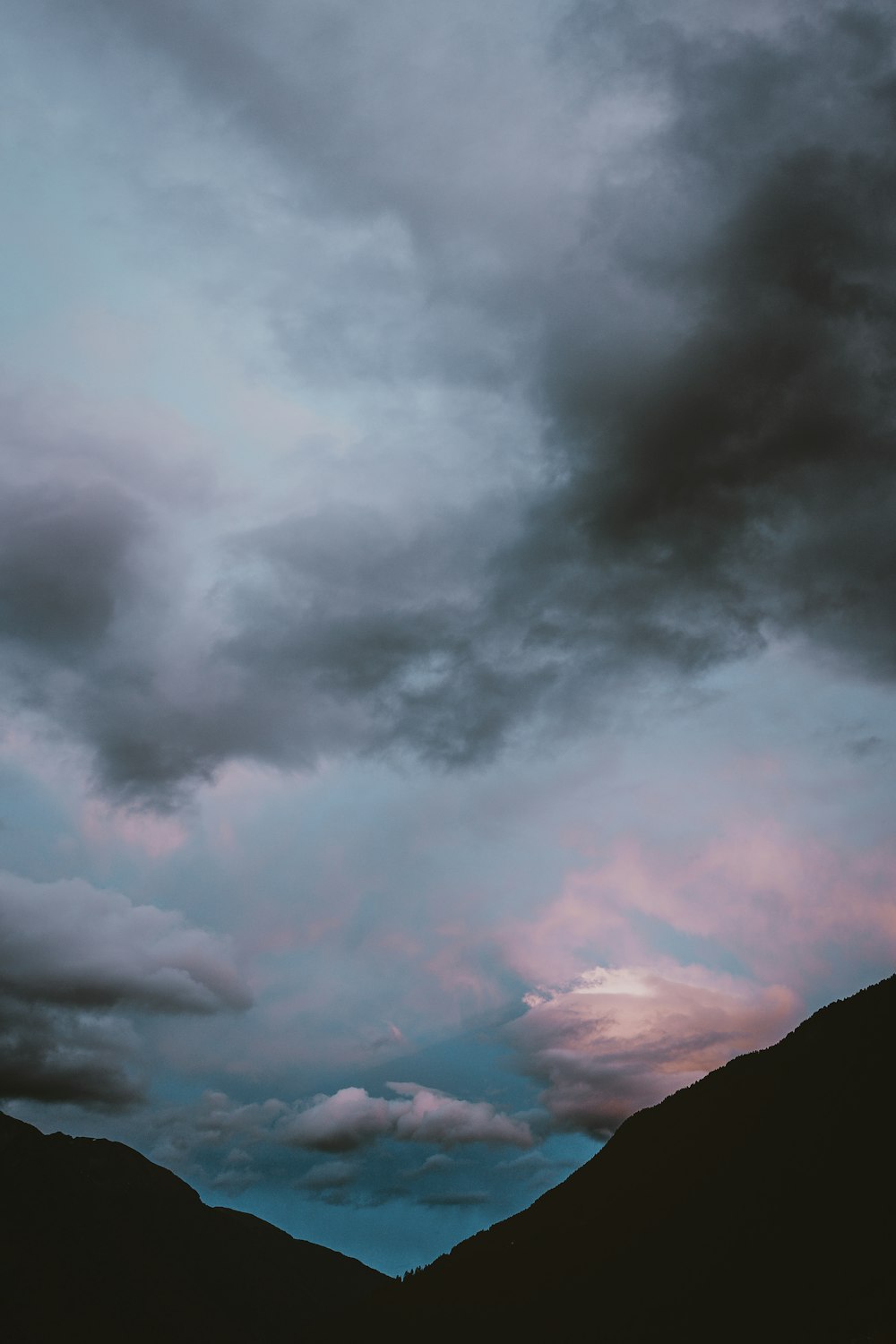 Fotografia di silhouette di montagne sotto nuvole di nimbo