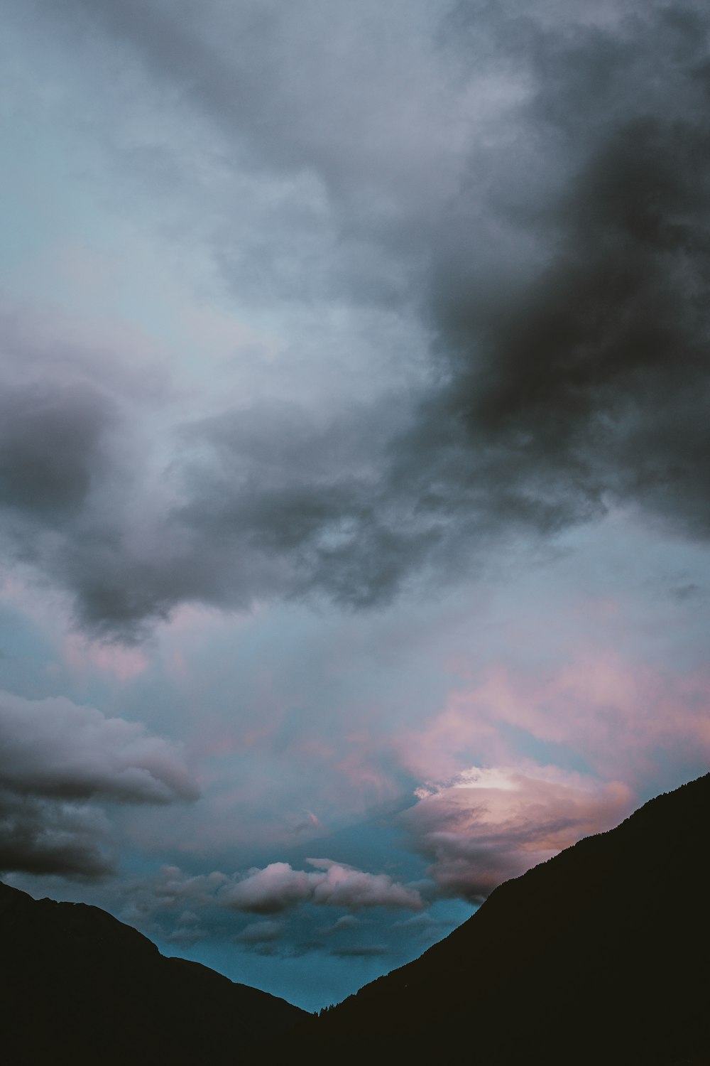 silhouette photography of mountains under nimbus clouds