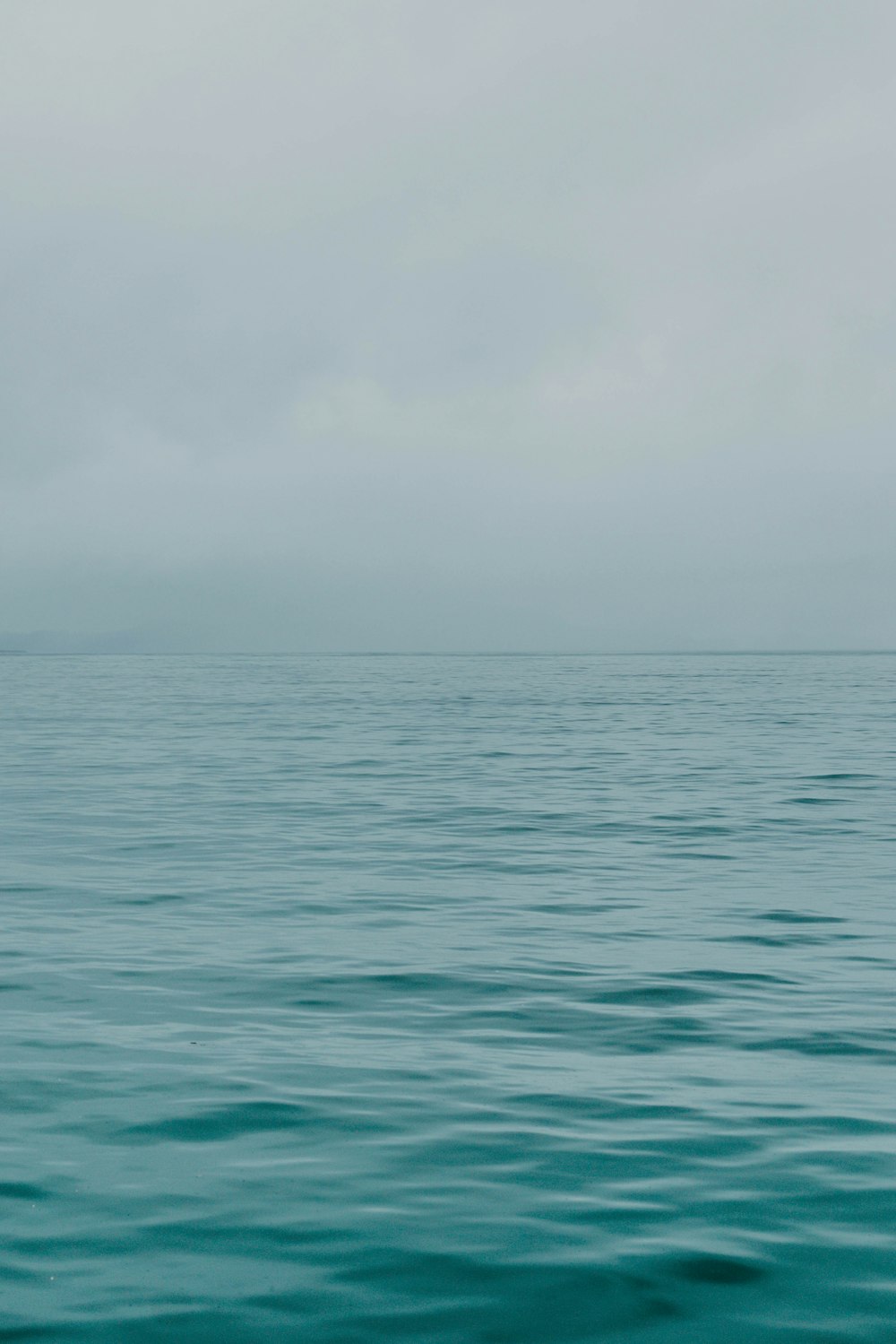 a large body of water with a boat in the distance