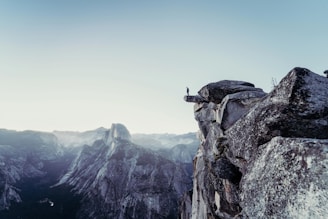 person standing on gray concrete cliff