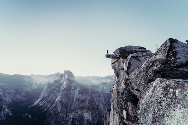 person standing on gray concrete cliff
