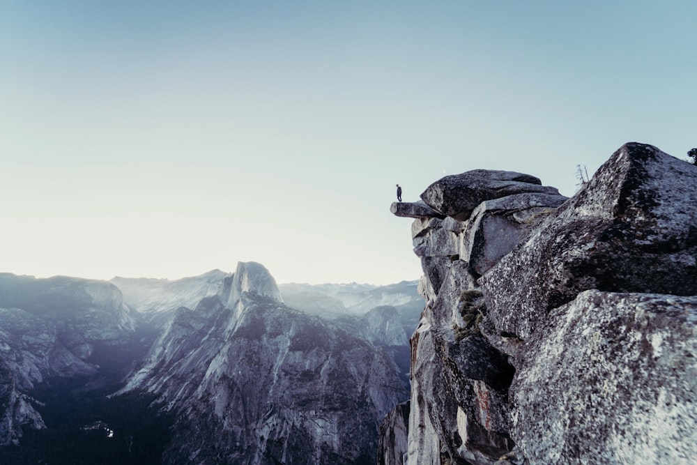 person standing on gray concrete cliff