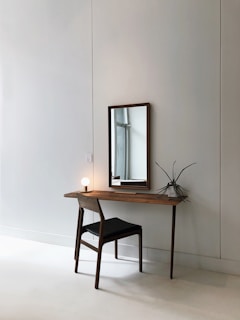 black leather chair with brown wooden frame in front of half table