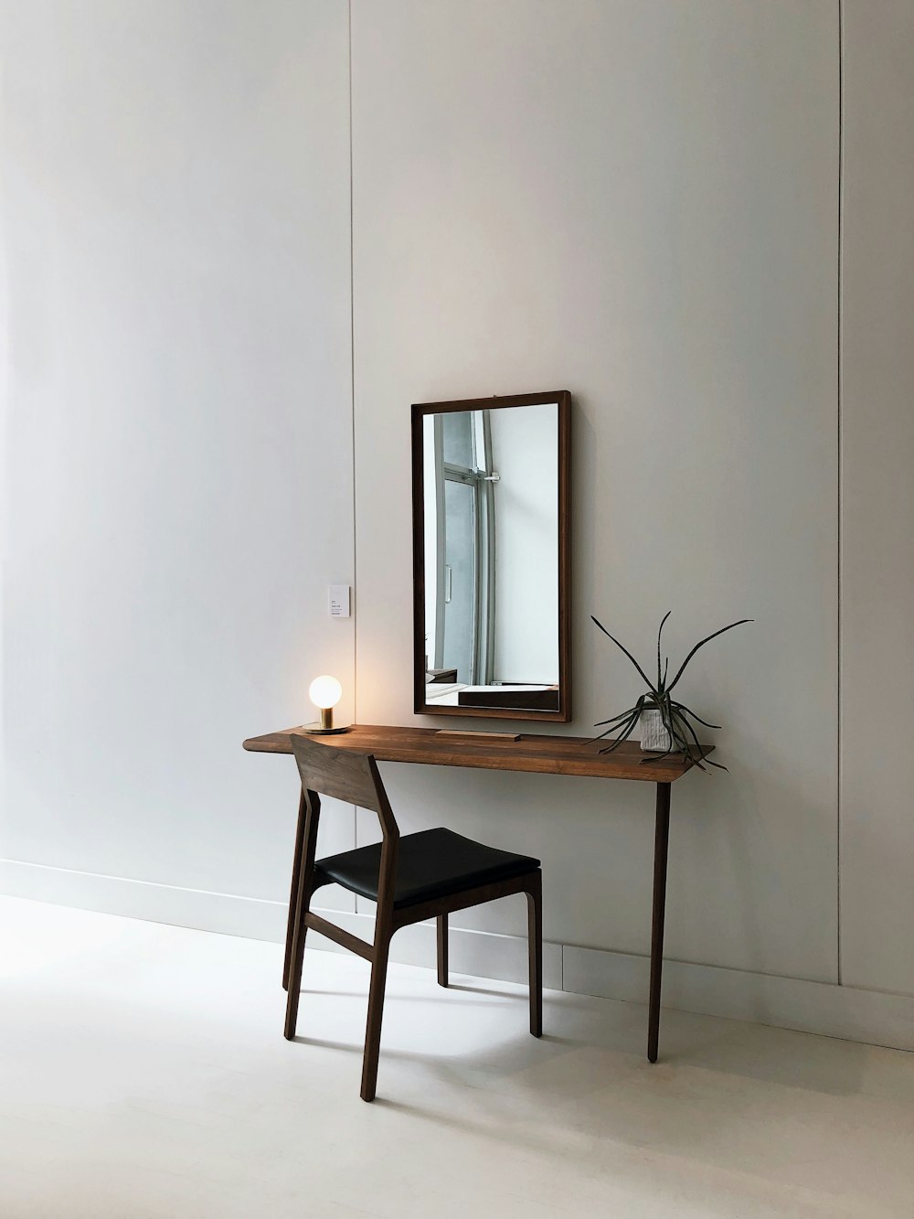 black leather chair with brown wooden frame in front of half table