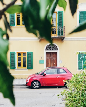 red FIAT 500 parked outside building