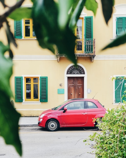 red FIAT 500 parked outside building