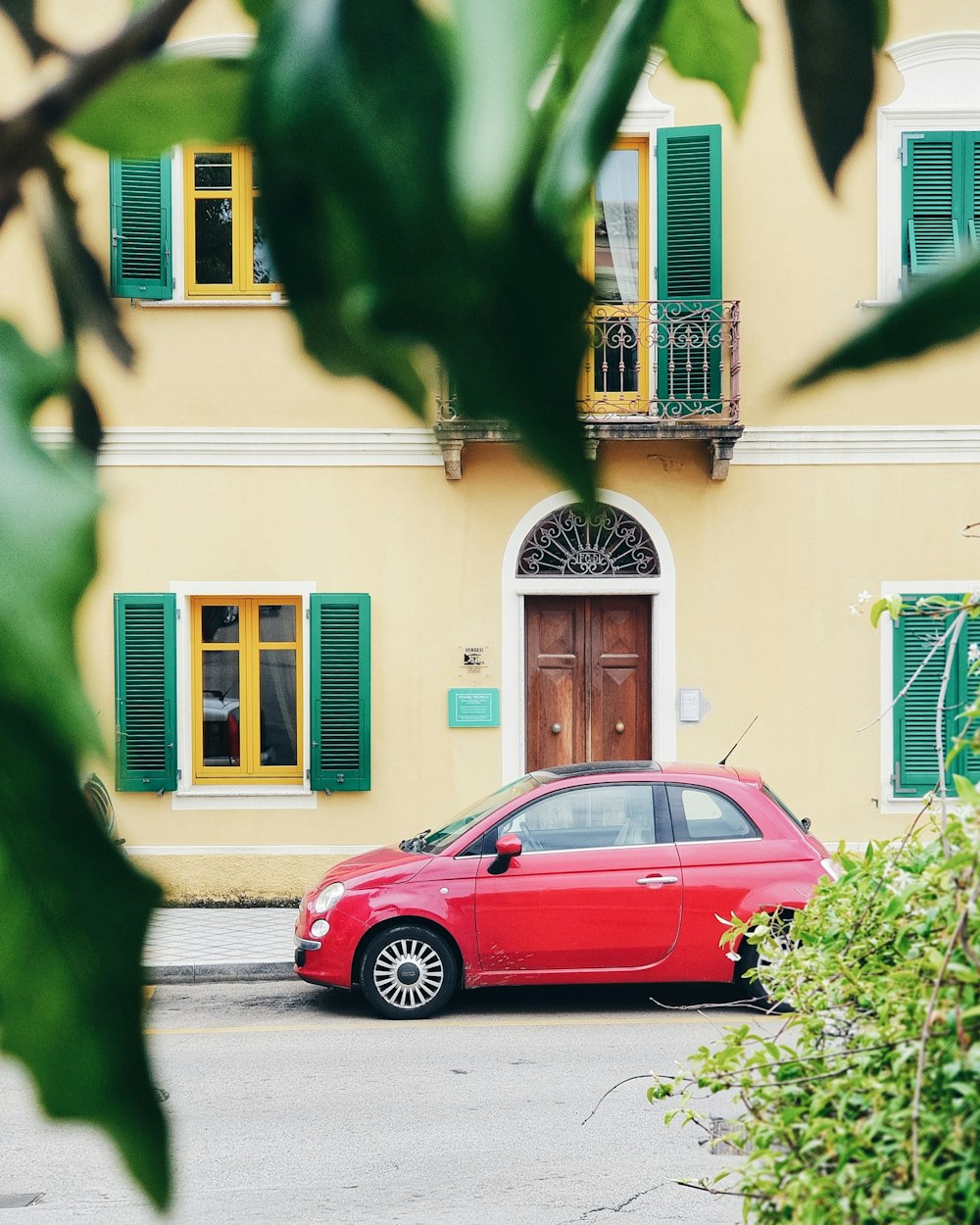 red FIAT 500 parked outside building