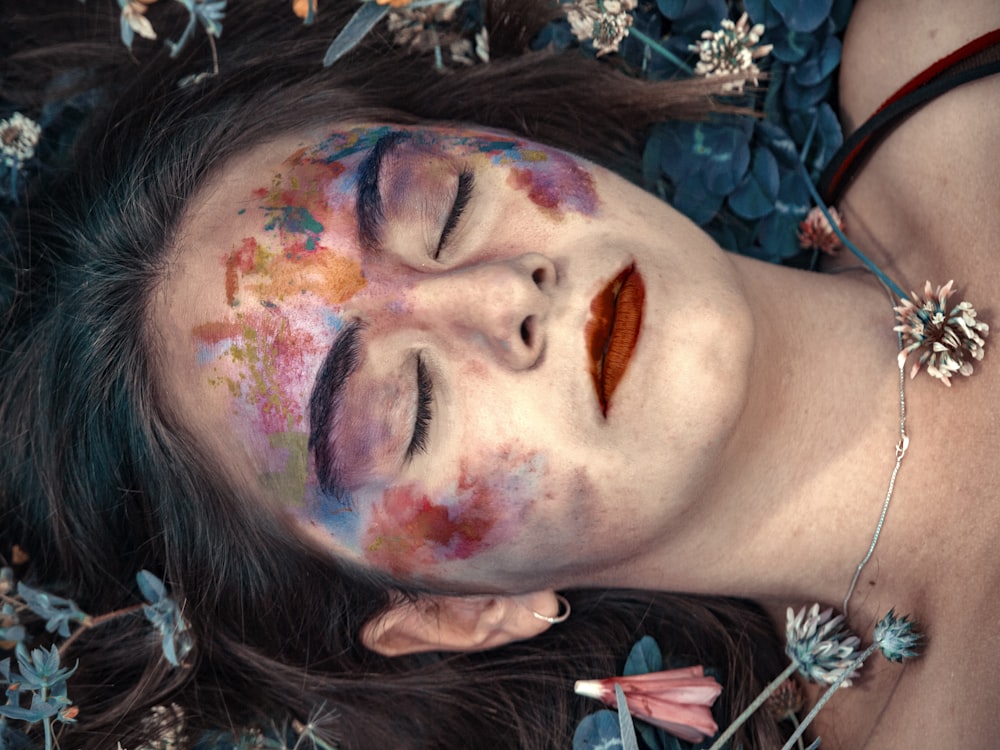 woman with multicolored makeup closed her eyes
