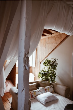 A cozy Airbnb living room freshly cleaned, featuring soft gold cushions and bright white curtains.