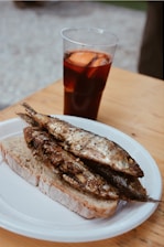 Close-up of a plate with crispy catfish, grilled veggies, and a glass of southern lemonade.