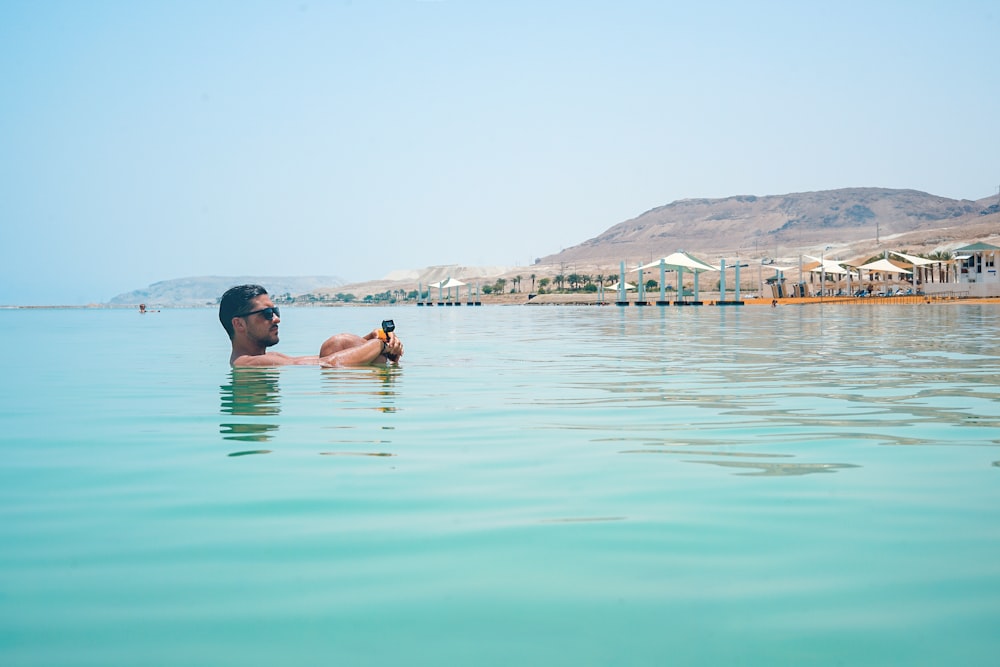 photo of man swimming in sea