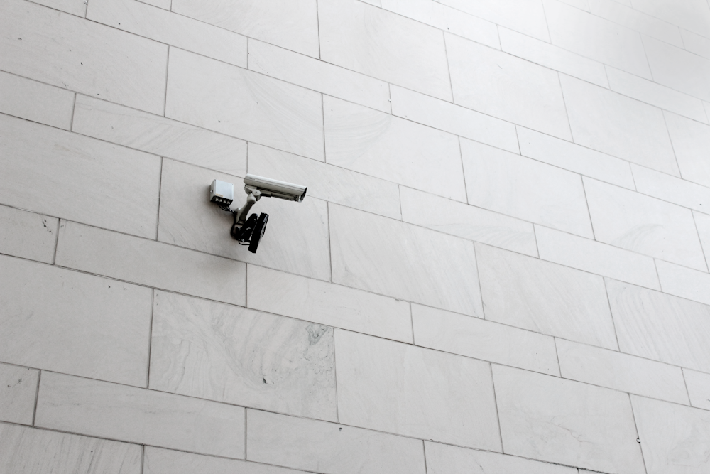 grey surveillance camera on wall