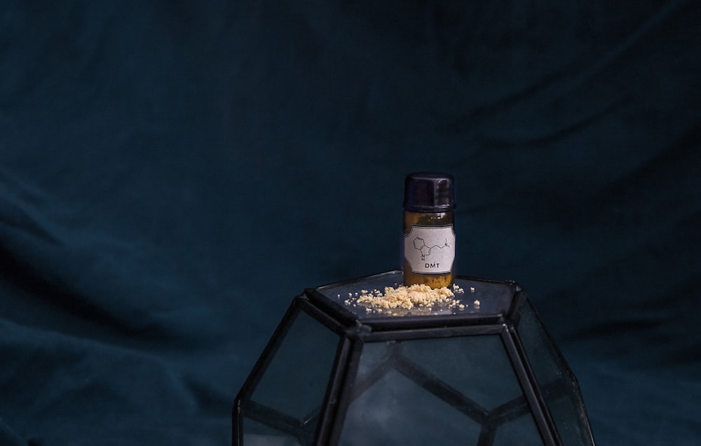 white labeled jar on top of cube ball on blue textile