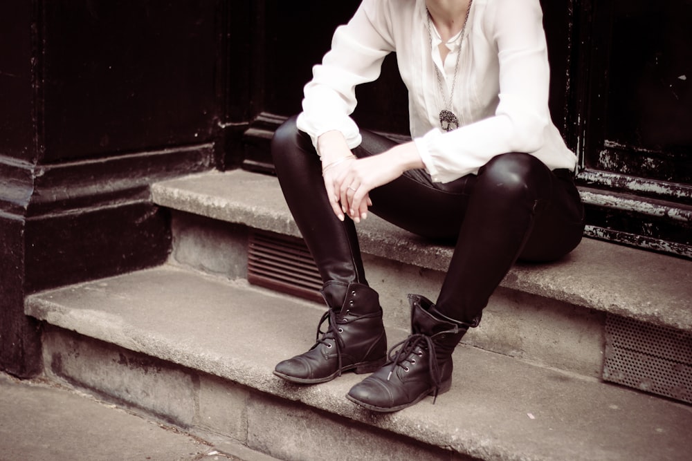 person sitting on stairs near door