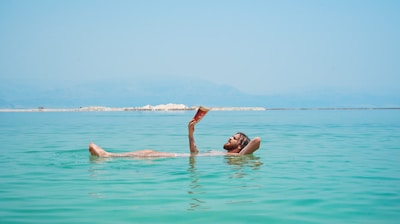 person on body of water reading book