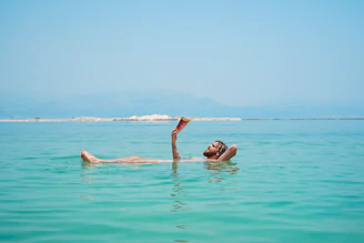 person on body of water reading book