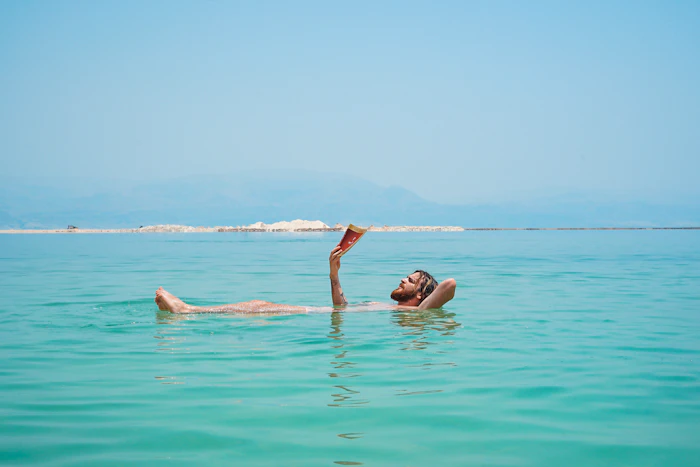 A traveler floating effortlessly in the turquoise Dead Sea
