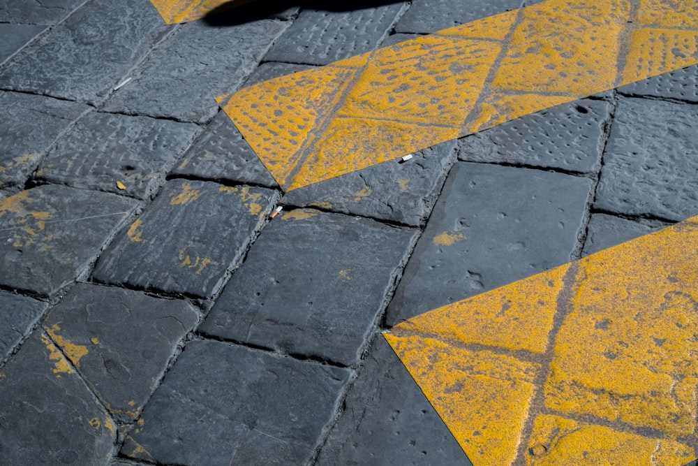 a yellow and black arrow painted on the ground