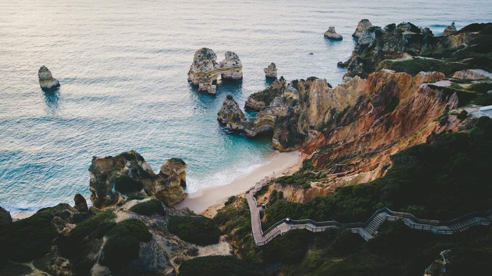 cliff near body of water with boulders