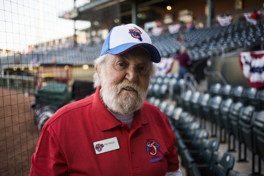 man wearing white and blue curve-brimmed cap