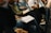 A group of diverse people engaged in a learning environment with laptops and notebooks.