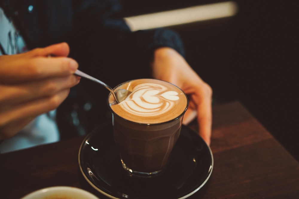 persona revolviendo el café con leche