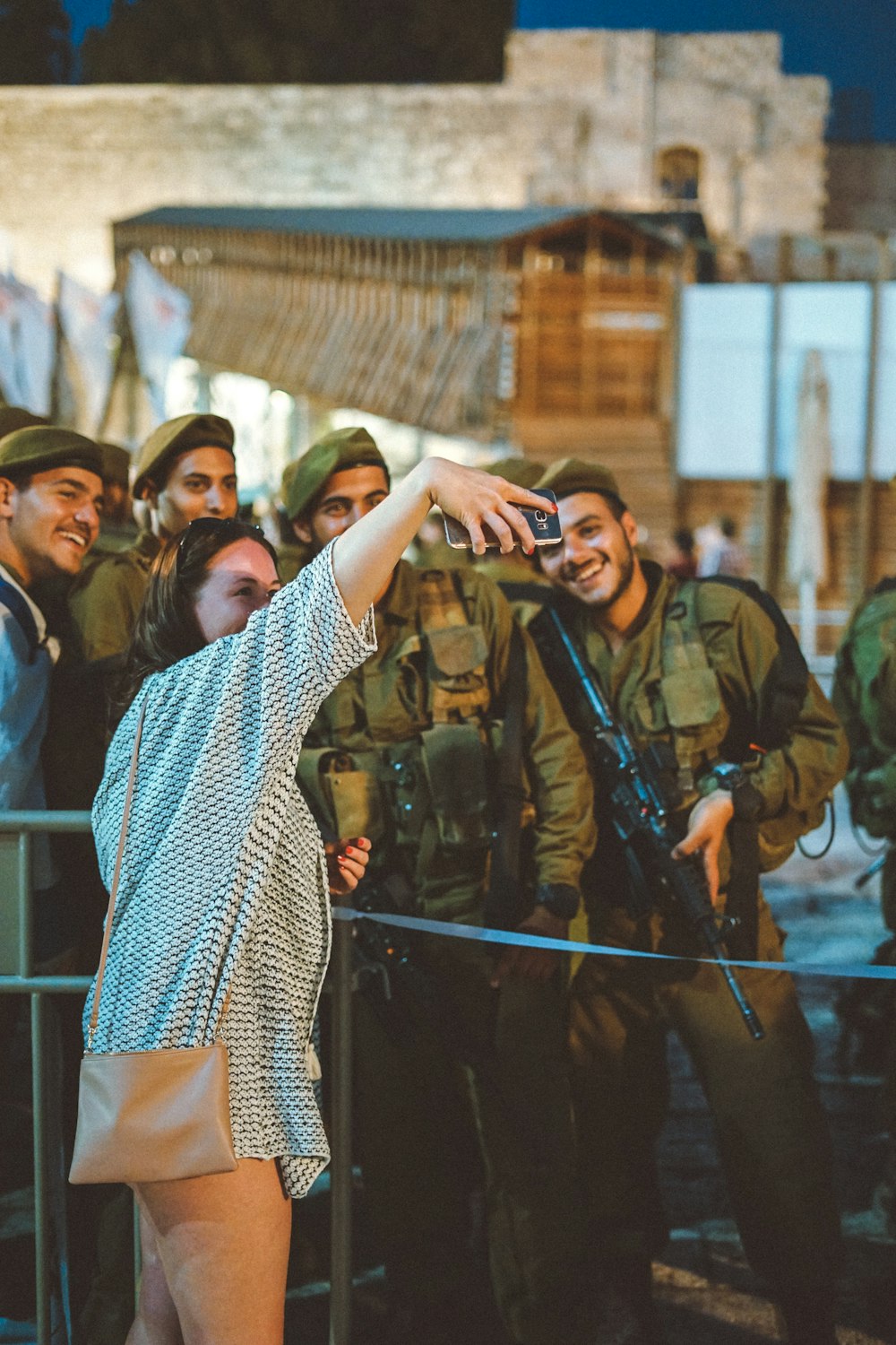 Donna che scatta una foto di groupie con quattro militari