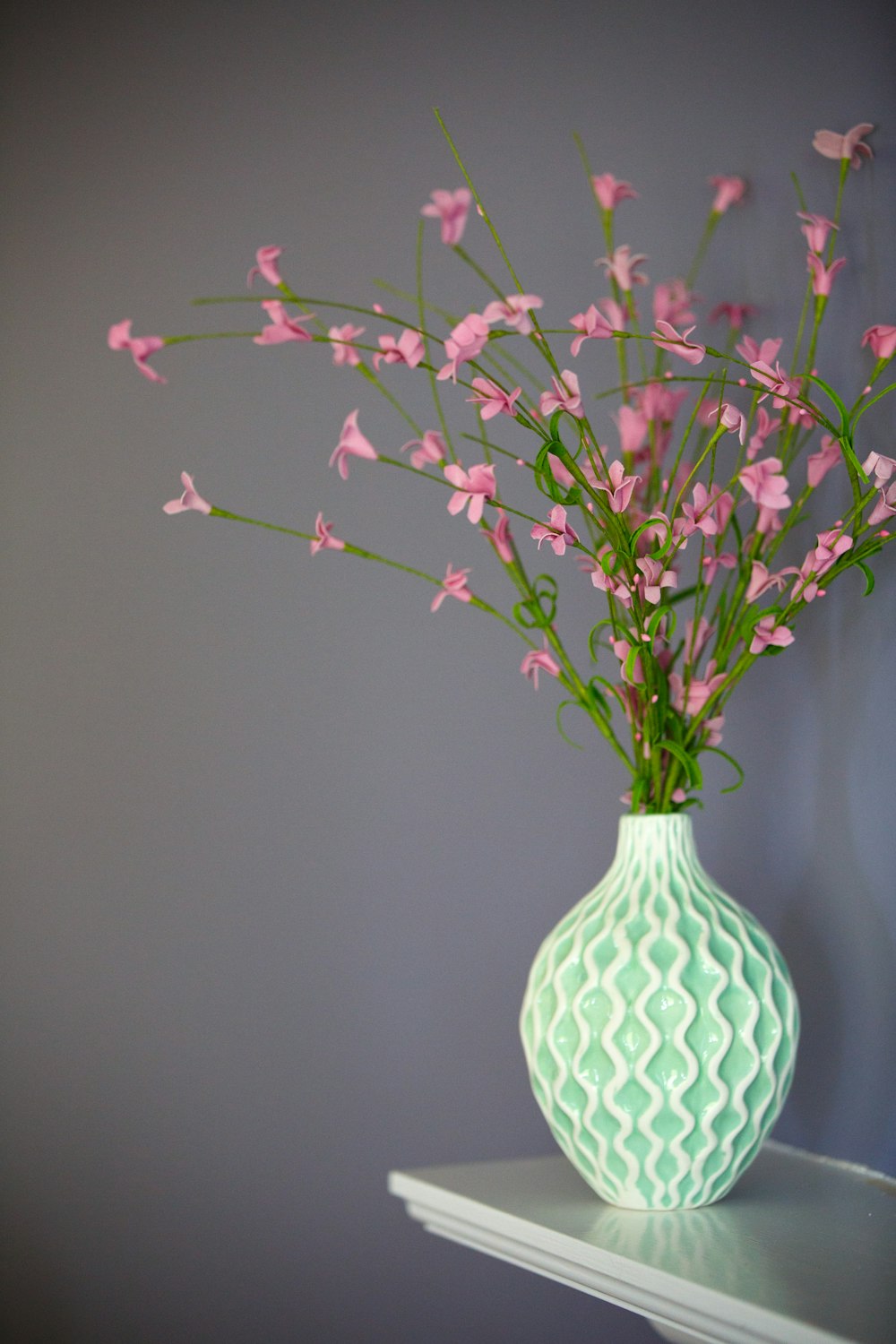 pink petaled flowers on green vase