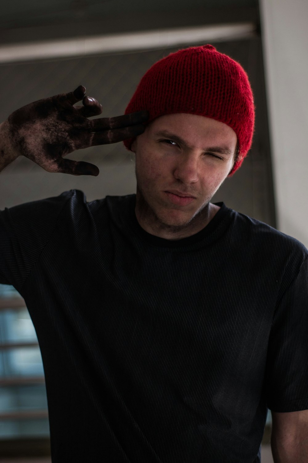 man wearing black crew-neck t-shirt pointing his head