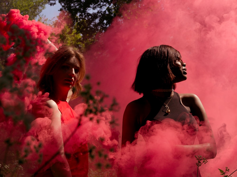 deux femmes couvertes de fumée rouge